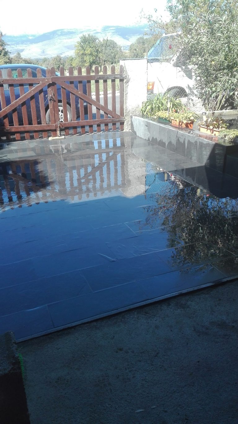 Reforma con integración de suelo pizarra para entrada vivienda